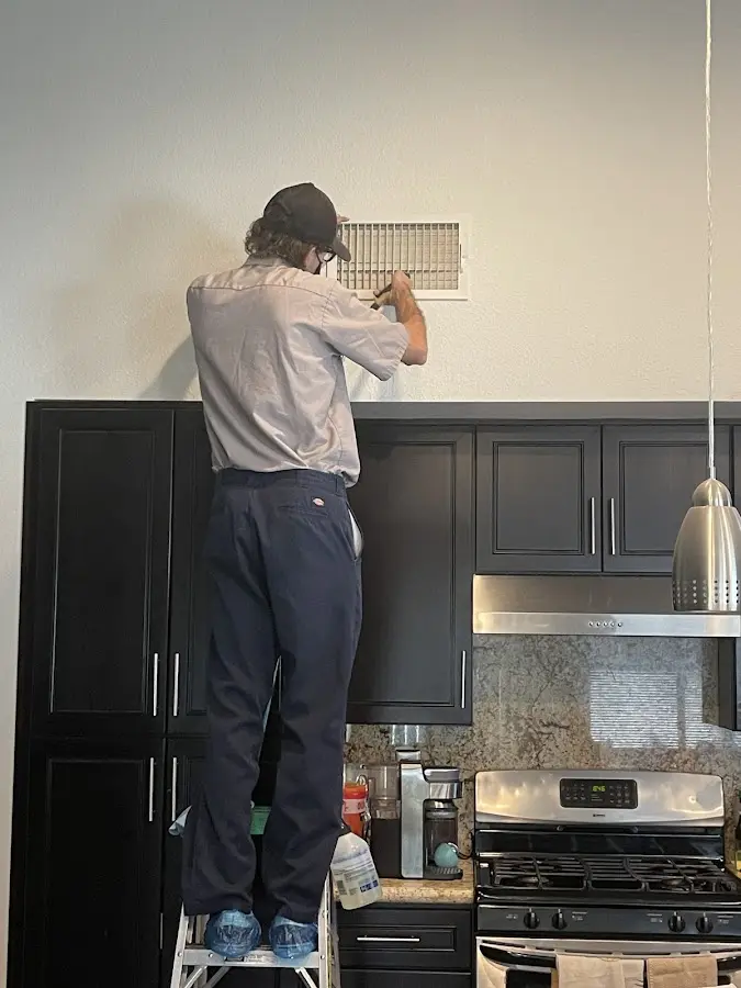 Technician inspecting an air vent during HVAC service in Hiawatha